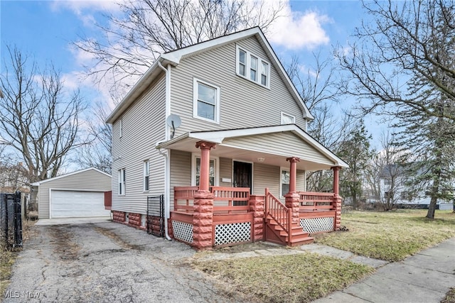 view of front of home with a porch, a detached garage, a front yard, and an outdoor structure