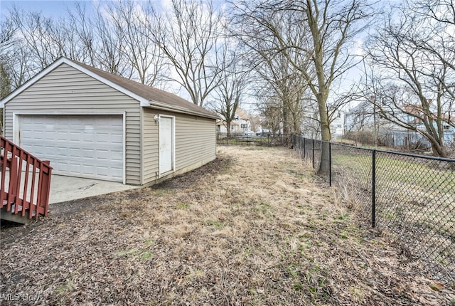 view of yard with a detached garage, an outdoor structure, and fence