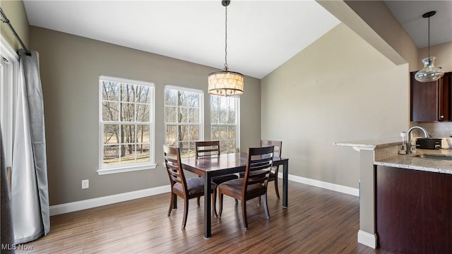 dining area with an inviting chandelier, baseboards, dark wood-style flooring, and lofted ceiling