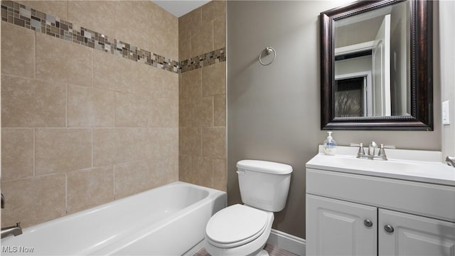 bathroom featuring baseboards, toilet, vanity, and bathtub / shower combination