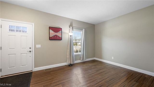 foyer entrance featuring baseboards and wood finished floors