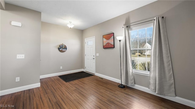 entryway with visible vents, baseboards, and dark wood-style flooring