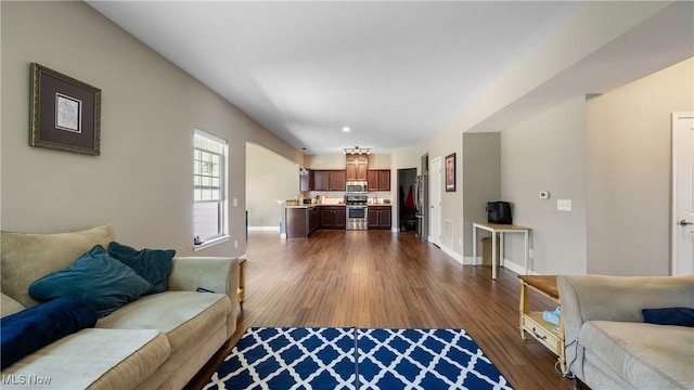 living area with baseboards and dark wood-style flooring