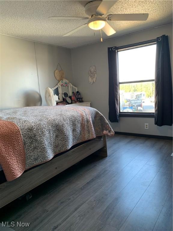 bedroom featuring a textured ceiling, a ceiling fan, and wood finished floors