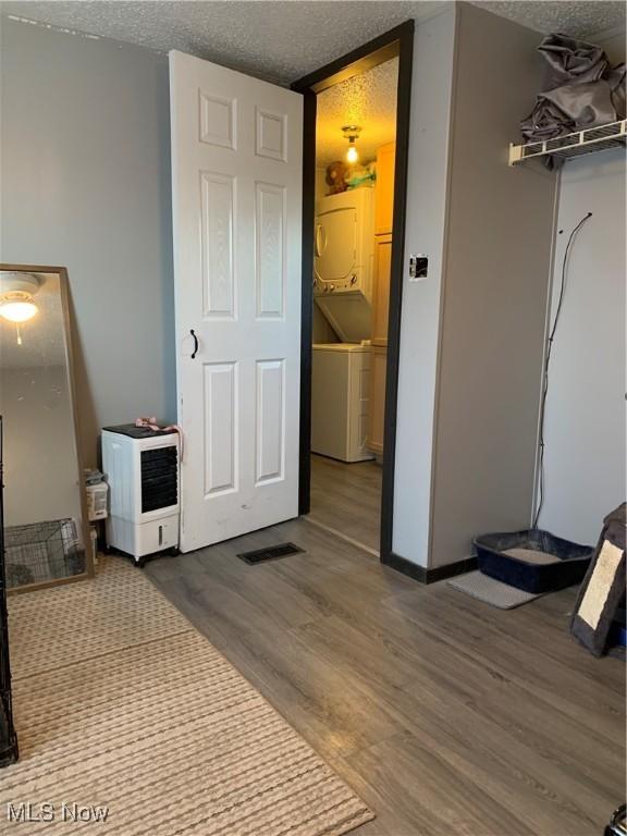 bedroom featuring visible vents, a textured ceiling, and wood finished floors