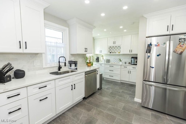 kitchen with white cabinets, tasteful backsplash, appliances with stainless steel finishes, and a sink