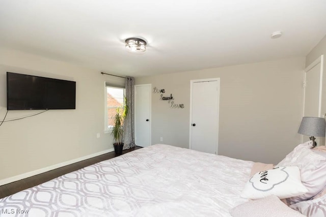 bedroom featuring wood finished floors and baseboards