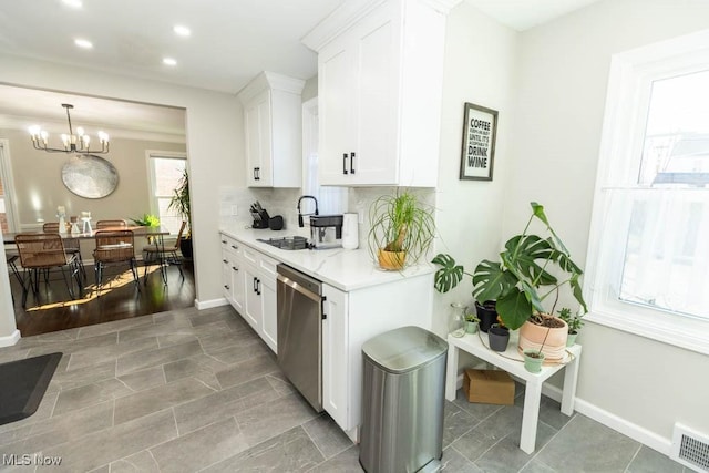 kitchen featuring visible vents, backsplash, light countertops, white cabinets, and stainless steel dishwasher