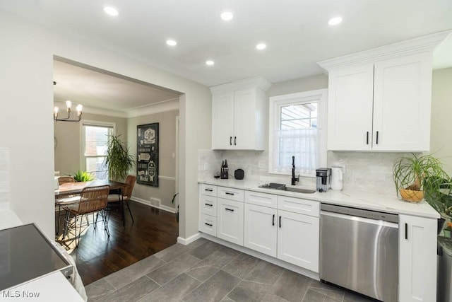 kitchen with a sink, tasteful backsplash, white cabinetry, an inviting chandelier, and dishwasher