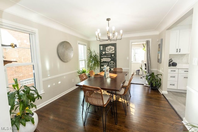 dining room featuring baseboards, an inviting chandelier, wood finished floors, and crown molding