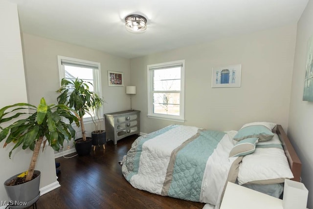 bedroom with wood finished floors and baseboards