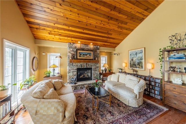 living area with high vaulted ceiling, a stone fireplace, wood ceiling, and wood finished floors