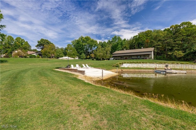 view of home's community with a water view and a lawn