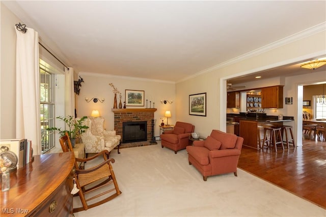 living area with a brick fireplace, wood finished floors, and crown molding