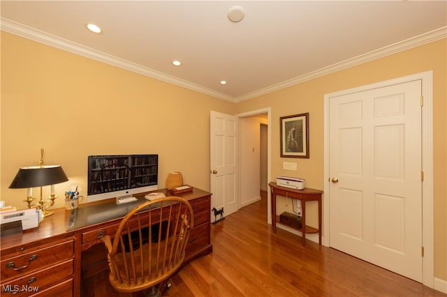 office featuring recessed lighting, wood finished floors, built in desk, and ornamental molding