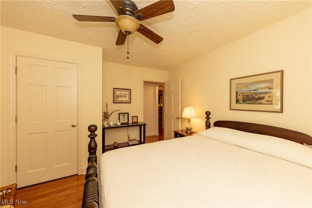 bedroom featuring ceiling fan, a textured ceiling, and wood finished floors