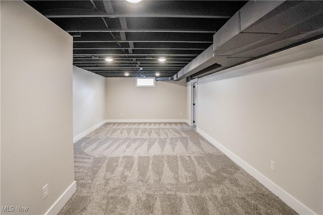 below grade area featuring carpet and baseboards