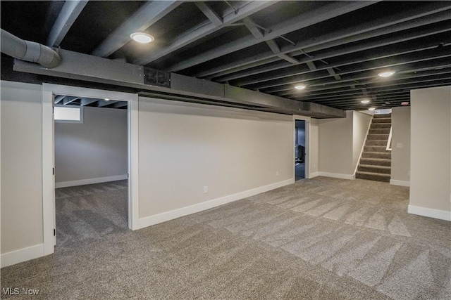 finished below grade area featuring stairs, carpet flooring, and baseboards