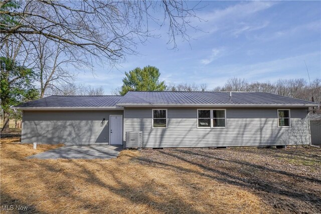 rear view of house featuring metal roof, central AC, and a patio area