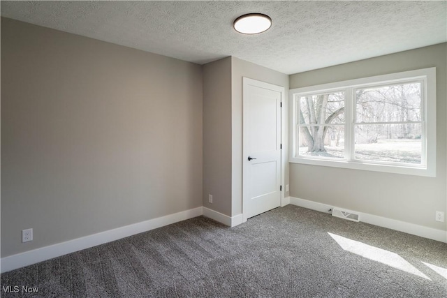 unfurnished bedroom featuring baseboards, visible vents, carpet floors, and a textured ceiling