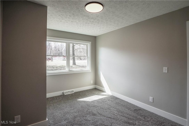 unfurnished room with visible vents, baseboards, a textured ceiling, and carpet floors