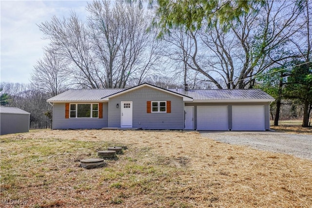 ranch-style home with metal roof, driveway, and an attached garage