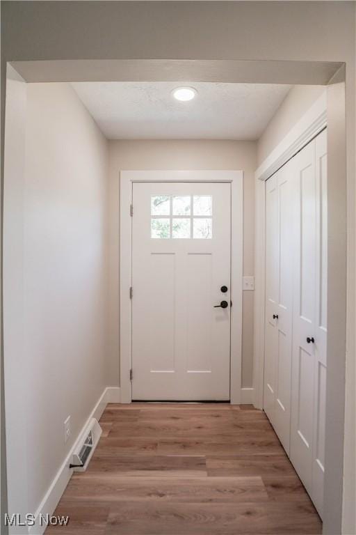 entryway with light wood-style floors, visible vents, and baseboards