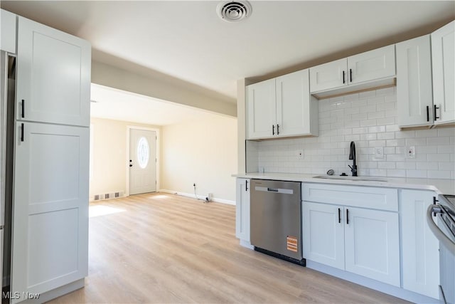 kitchen with visible vents, a sink, decorative backsplash, light countertops, and dishwasher