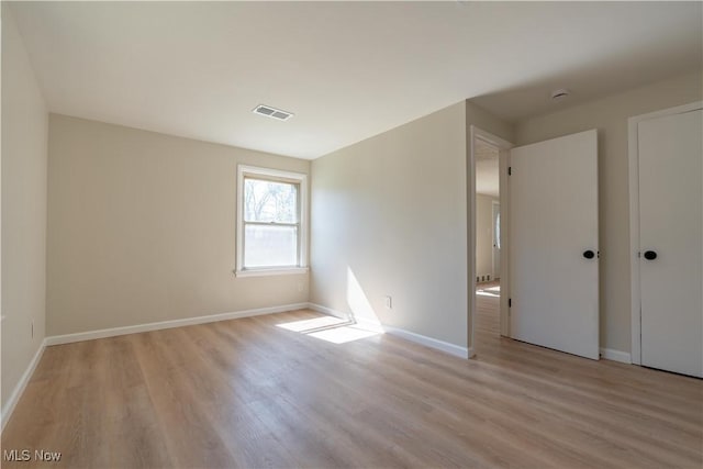 unfurnished bedroom with light wood finished floors, visible vents, and baseboards