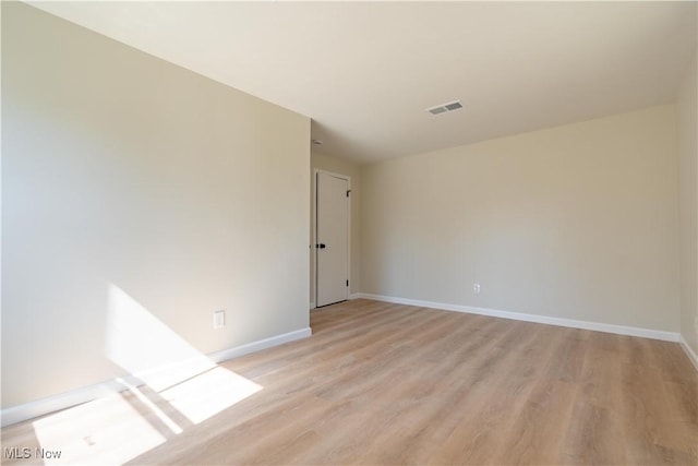 spare room with visible vents, baseboards, and light wood-style floors