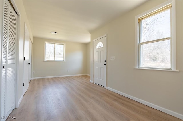 foyer with light wood-type flooring and baseboards