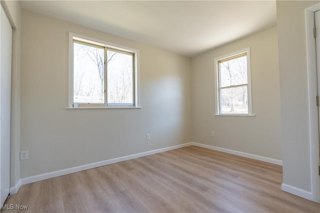 spare room featuring light wood-style flooring and baseboards