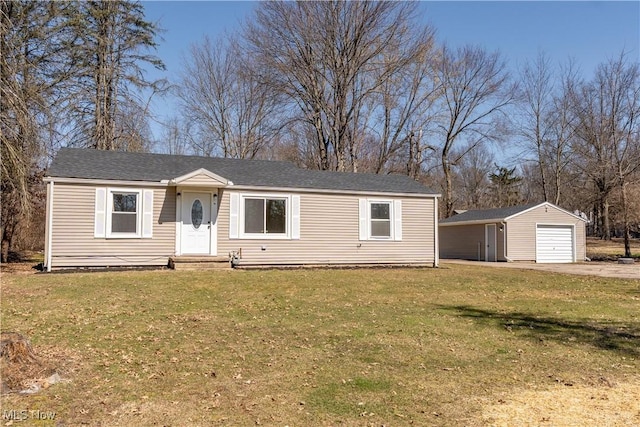 view of front of home featuring a front lawn, a detached garage, and an outdoor structure