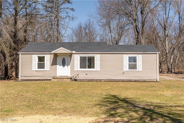 view of front of home featuring a front yard and roof with shingles