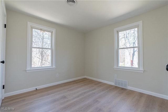 unfurnished room featuring visible vents, baseboards, and light wood-style flooring