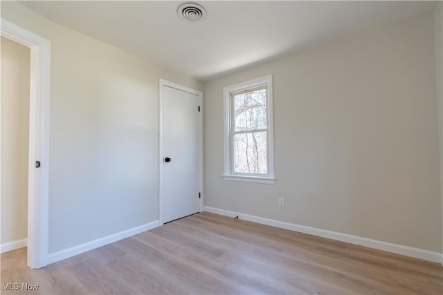 unfurnished bedroom featuring baseboards, visible vents, a closet, and light wood-type flooring