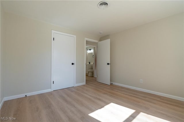 unfurnished bedroom featuring visible vents, light wood-style flooring, and baseboards