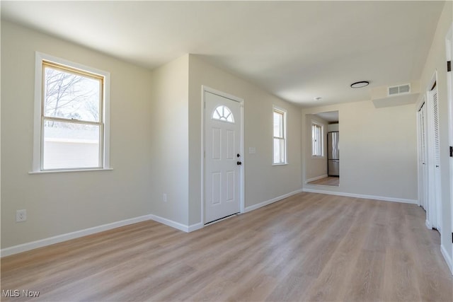 entryway with light wood finished floors, visible vents, and a wealth of natural light