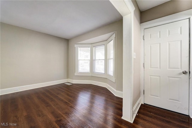 entrance foyer featuring baseboards and dark wood-type flooring