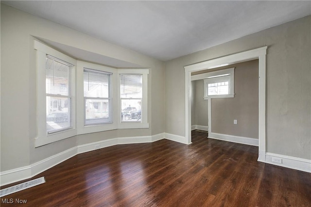 spare room featuring wood finished floors and baseboards