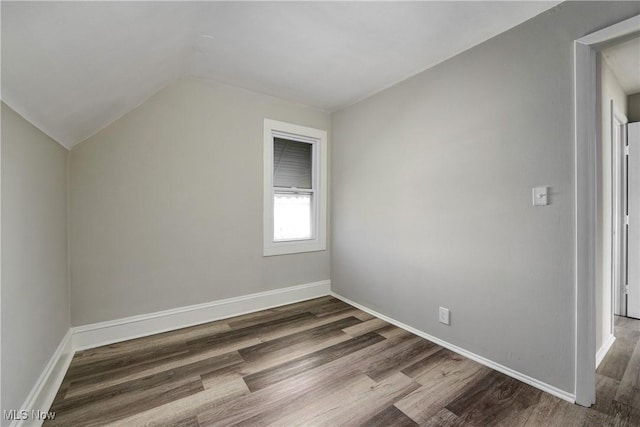 additional living space with vaulted ceiling, wood finished floors, and baseboards