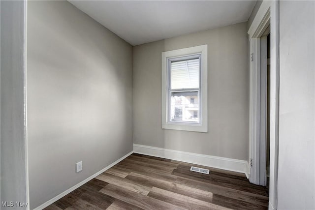 unfurnished bedroom with visible vents, baseboards, and dark wood-style flooring