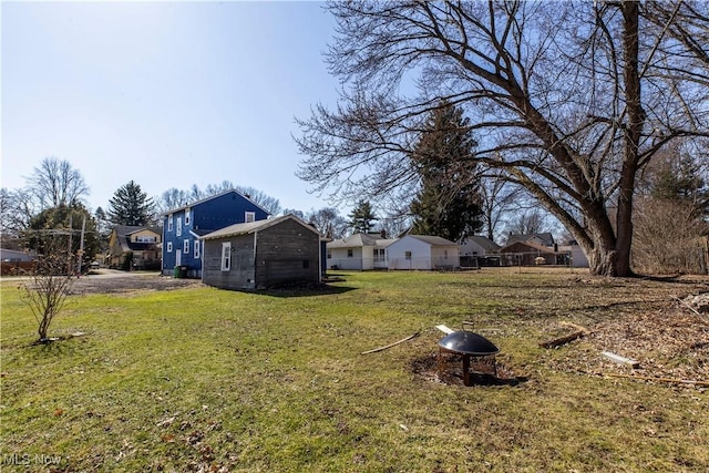 view of yard with a residential view and an outdoor fire pit