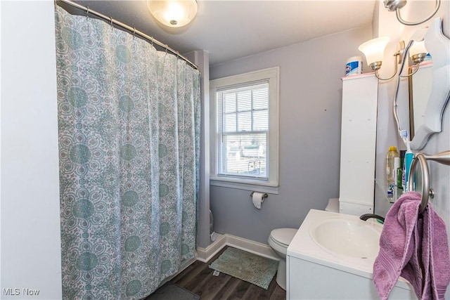 full bath featuring toilet, curtained shower, wood finished floors, baseboards, and vanity