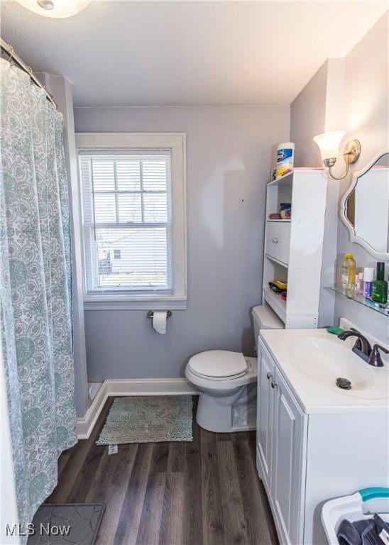 full bath featuring toilet, curtained shower, wood finished floors, baseboards, and vanity