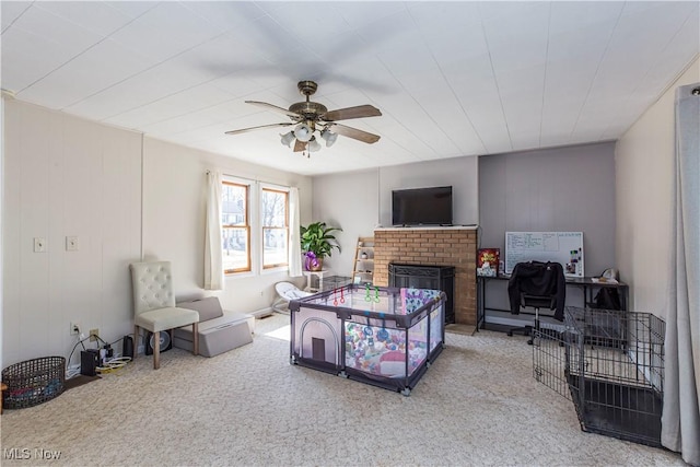 carpeted bedroom with a brick fireplace and ceiling fan