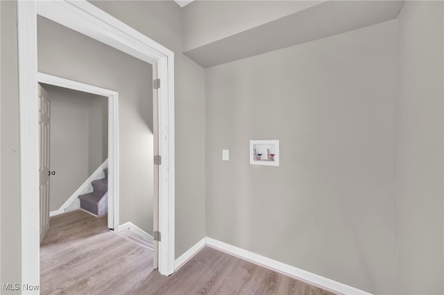 laundry area featuring laundry area, light wood-type flooring, baseboards, and washer hookup