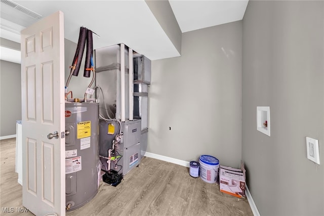 utility room with visible vents and water heater