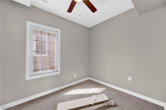 carpeted spare room with ceiling fan and baseboards