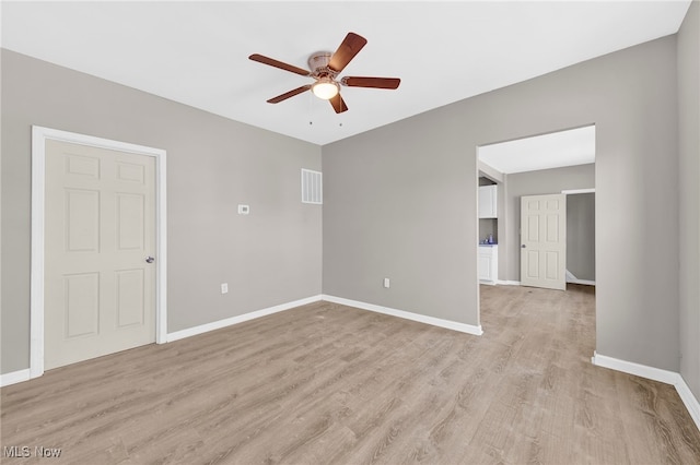 empty room with light wood finished floors, visible vents, baseboards, and a ceiling fan